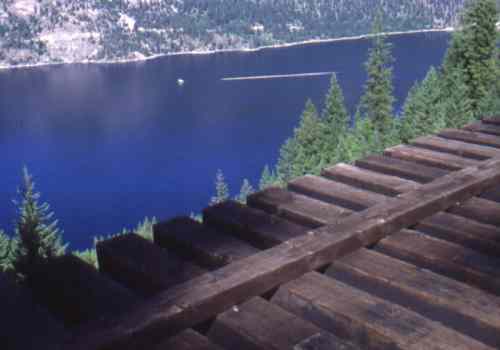 Steel & timber trestle overlooking log boom & barge on Lower Arrow Lake.